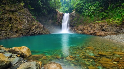 Waterfall cascading into a turquoise pool in a vibrant forest