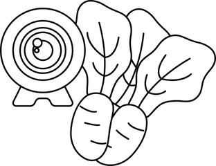 A camera is on a table next to a bunch of vegetables