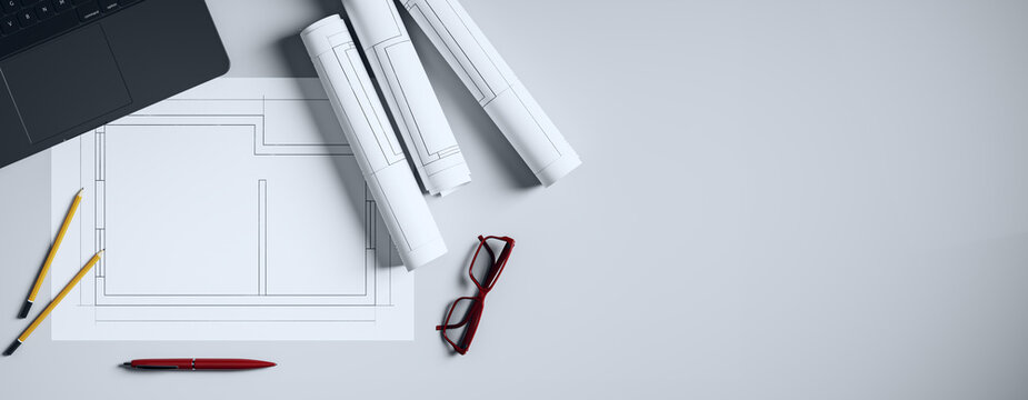 Top view of architecture desk with blueprints, pencils, glasses, and laptop on light background in modern office workspace setting. 3D Rendering