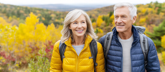 Smiling senior couple walking outdoors during autumn season, surrounded by colorful foliage, symbolizing active lifestyle, companionship and joyful later-life moments.
