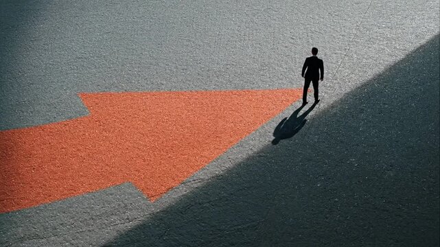 Man walking on a large red arrow pointing up. Business growth, success, and progress concept. Corporate development and forward movement.