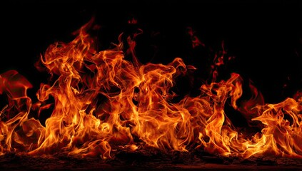 Obraz premium Bright orange flames dancing against a black background, showing high heat