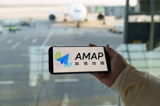 Beijing, China - Dec 05, 2025: Person holding cellphone with logo of Chinese online map service company AMap