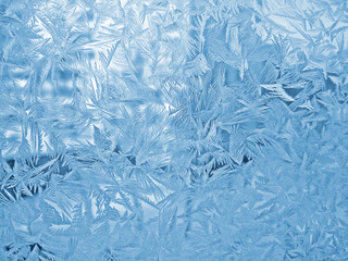 Beautiful ice pattern on window glass, close-up natural winter background