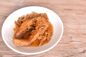 deep fried chop red Tilapia or mango fish slice dressing soy sauce and celery on plate 