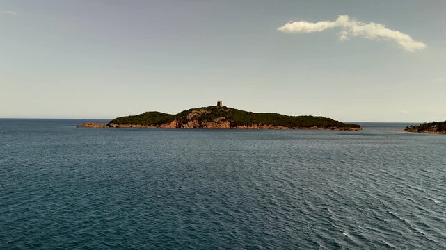Smooth Aerial Drone Approach Gliding Over Turquoise Mediterranean Sea Towards the Historic Genoese Tower on Pinarello Islet off the Coast of Cape Fora, Corsica, France.
