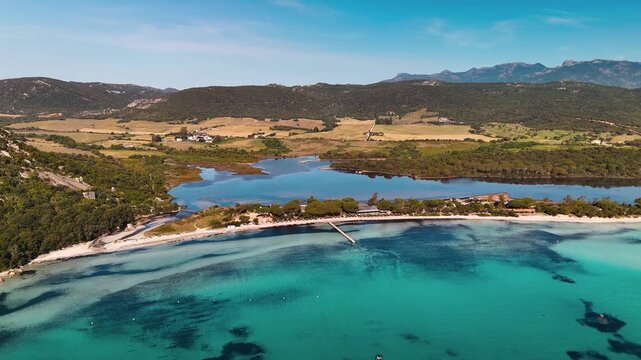 Cinematic Aerial Approach Shot Flying Over Pristine White Sand Beach Towards Santa Giulia Lagoon and Turquoise Mediterranean Sea, Porto Vecchio, Corsica, France.