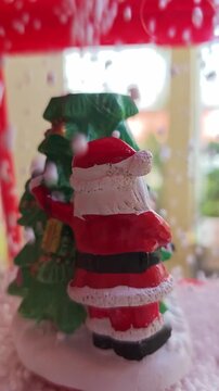 Festive Miniature Santa Claus Figurine Standing Next Green Christmas Tree Inside Glass Snow Globe Decoration With Magical Winter Snowflake Falling Creates Joyful Holiday Season Spirit Xmas Mood