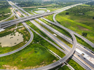 Drone shot a large highway interchange crossing over green farmlands in Thailand
