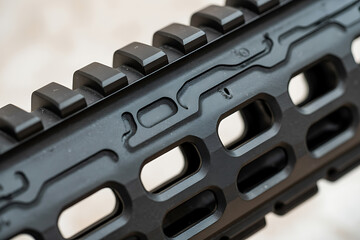 Close up detailed view of a black tactical firearm handguard with picatinny rails and m lok slots