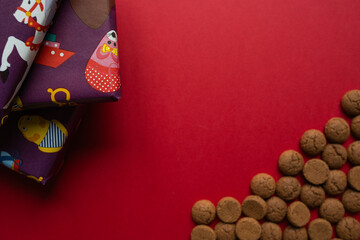A textured still life of meticulously wrapped presents and artfully scattered gingerbread cookies pops against an intense purple backdrop, perfect for capturing the tactile joy 