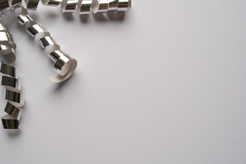 Elegantly twisted ribbons of silver confetti create dynamic spiral patterns against a clean white background. Visual assets for motion graphics, festive branding, and lively background designs.