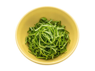 Isolated image of freshly chopped green cabbage leaves in a yellow bowl, ready for cooking