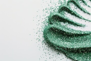 A swirl of green glitter lays on a light background. The sparkle reflects light and adds a festive touch. This decoration is perfect for St Patricks Day parties or events