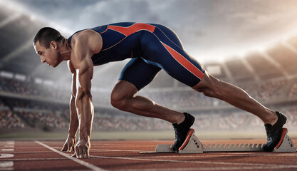 Muscular male runner starting race at stadium