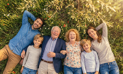 Happy family relax lying on grass, top view