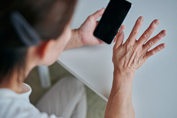 スマホでビデオ通話するシニア女性