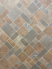 Floor tiles in a diagonal pattern with a natural stone texture, featuring a mix of gray, beige, and brown tones