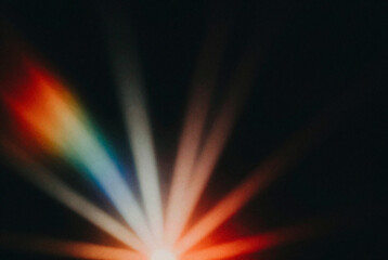 Close up of a colorful light beam on a black background.