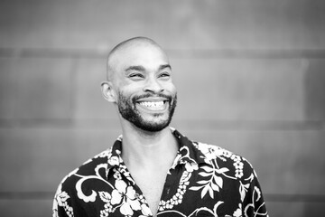Black and white portrait of smiling bald man in tropical shirt