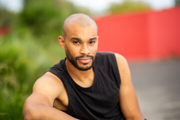Confident man with beard in sleeveless t-shirt looking at camera