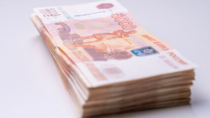 A large stack of Russian banknotes with a face value of 5,000 rubles on a white background. The concept of a large amount of cash in large bills. High quality photo
