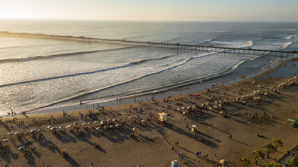 Drone photos of Pimentel Beach, Peru, capturing the pier, rolling waves and crowds enjoying a warm summer day on the northern coast. Ideal for travel, tourism and coastal destination content
