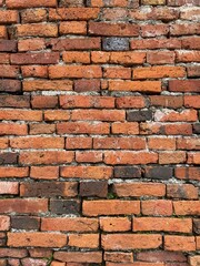 Obraz premium Old brick wall in Thailand, ruins of an old temple, bricks blackened by moisture