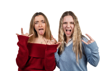 Young women expressing rebellion with rock and roll hand gestures