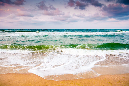 black sea waves crashing sandy beach of bulgaria. summer vacation on a windy weather day under dark cloudy sky. view of dramatic seascape. background for desperate tourism in bad weather concept