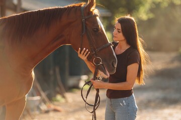 Obraz premium Non urban country scene. Woman is with horse on the farm