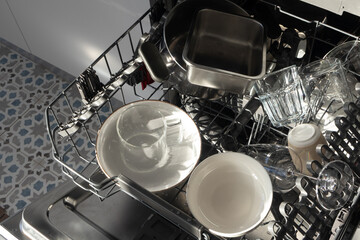 Open dishwasher with clean dishes in morning sunlight. Cleaning routines, sustainable living, and daily chores