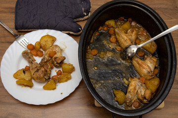 Pan of cooked chicken and potatoes sits beside a plated serving, showing a warm homemade meal ready to be enjoyed as a comforting family dinner at the kitchen table.