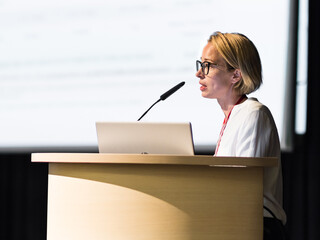 Female speaker giving a talk on corporate business conference. Business and Entrepreneurship event