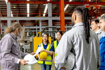Supervisor of diverse engineers briefing his team before working in manufacturing factory. Leader giving a briefing to team in industrial site. Worker manager conducting a site meeting in a factory.