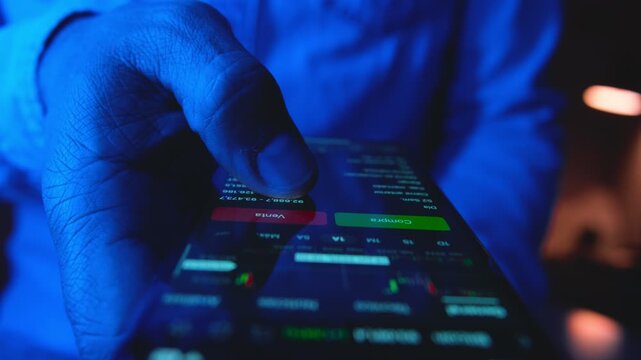 Close-up of a businessman's hand checking a financial stock market graph on a mobile device
