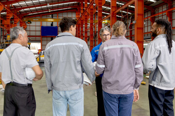 Supervisor of diverse engineers briefing his team before working in manufacturing factory. Leader giving a briefing to team in industrial site. Worker manager conducting a site meeting in a factory.
