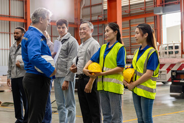 Supervisor of diverse engineers briefing his team before working in manufacturing factory. Leader giving a briefing to team in industrial site. Worker manager conducting a site meeting in a factory.