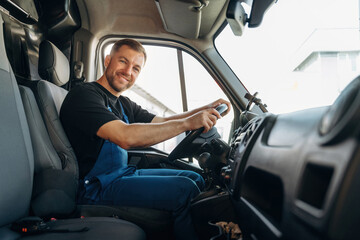 Cheerful smile, looking at the camera. Inside of the bus with delivery service man in uniform