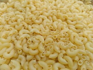 Close up shot of dried uncooked macaroni pasta.
