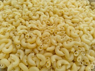 Close up shot of dried uncooked macaroni pasta.