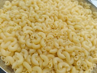 Close up shot of dried uncooked macaroni pasta.