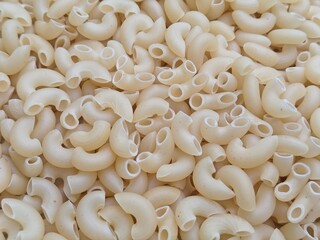 Close up shot of dried uncooked macaroni pasta.