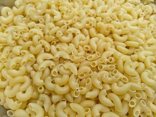 Close up shot of dried uncooked macaroni pasta.