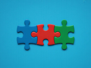 Obraz premium Three vibrant puzzle pieces connect perfectly demonstrating teamwork success and essential business solutions integration