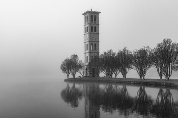 Clock tower on a lake on a foggy morning