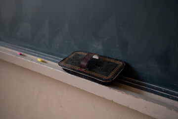 Classroom Blackboard with Chalk Eraser Resting on the Chalk Tray