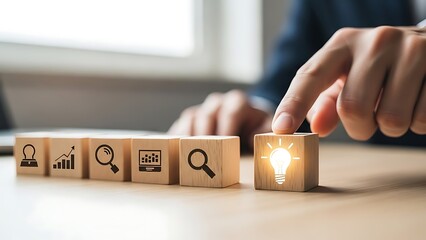 Businessman selecting light bulb icon among strategy icons on wooden cubes