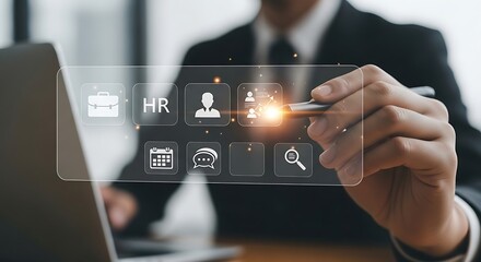 A businessman interacts with a transparent digital display showing human resources icons and data analytics on a laptop
