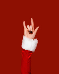 Santa-style hand making rock gesture on red background. Christmas promotions, festive campaigns, winter ads